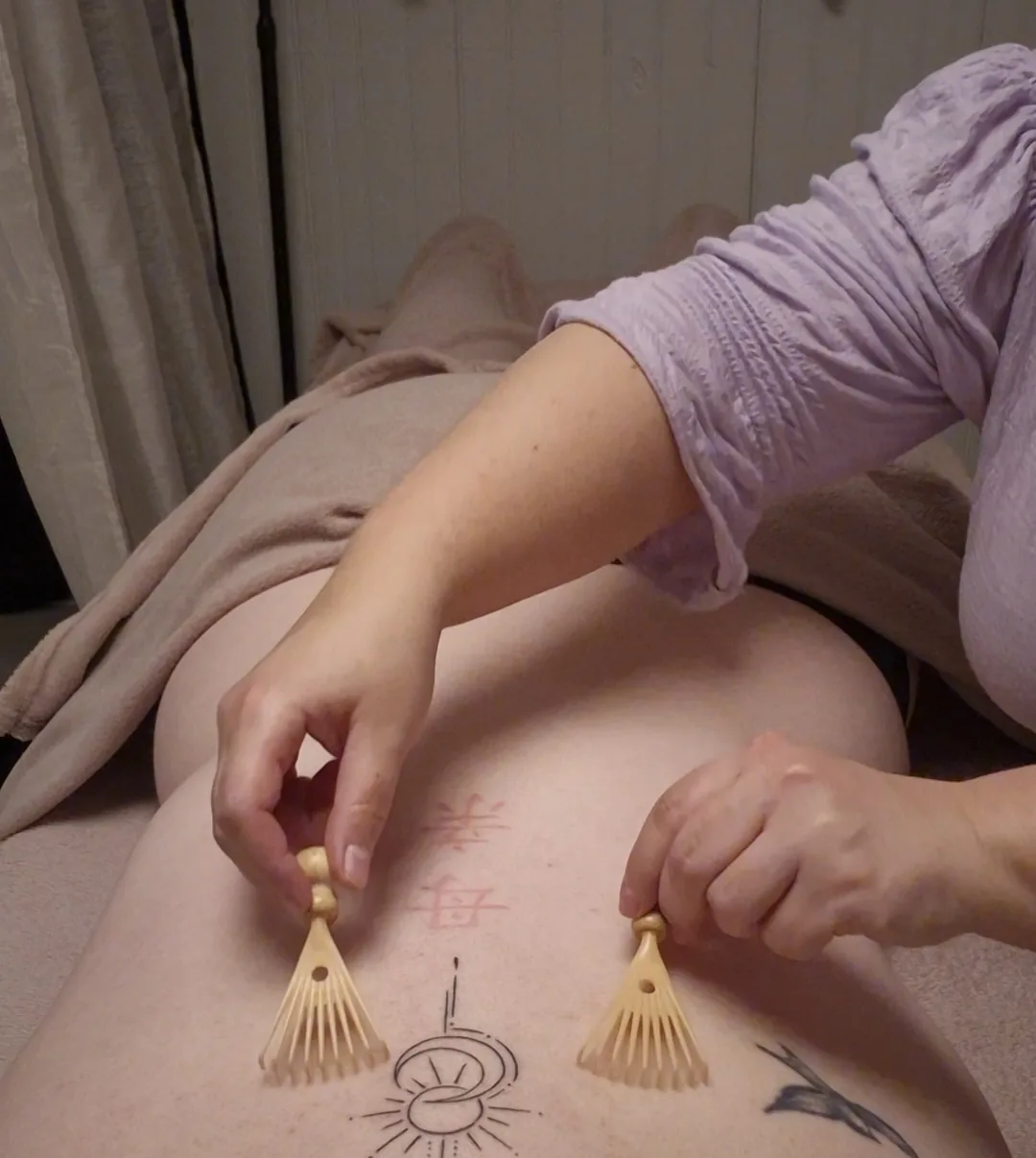 Deux accessoires sensoriels en bois utilisés sur le dos pendant une Caresse Sensorielle